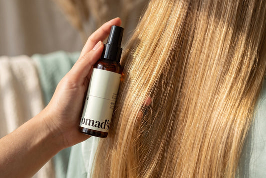 Spray éclaircissant OMAD'S tenu contre des longueurs de cheveux blonds brillants