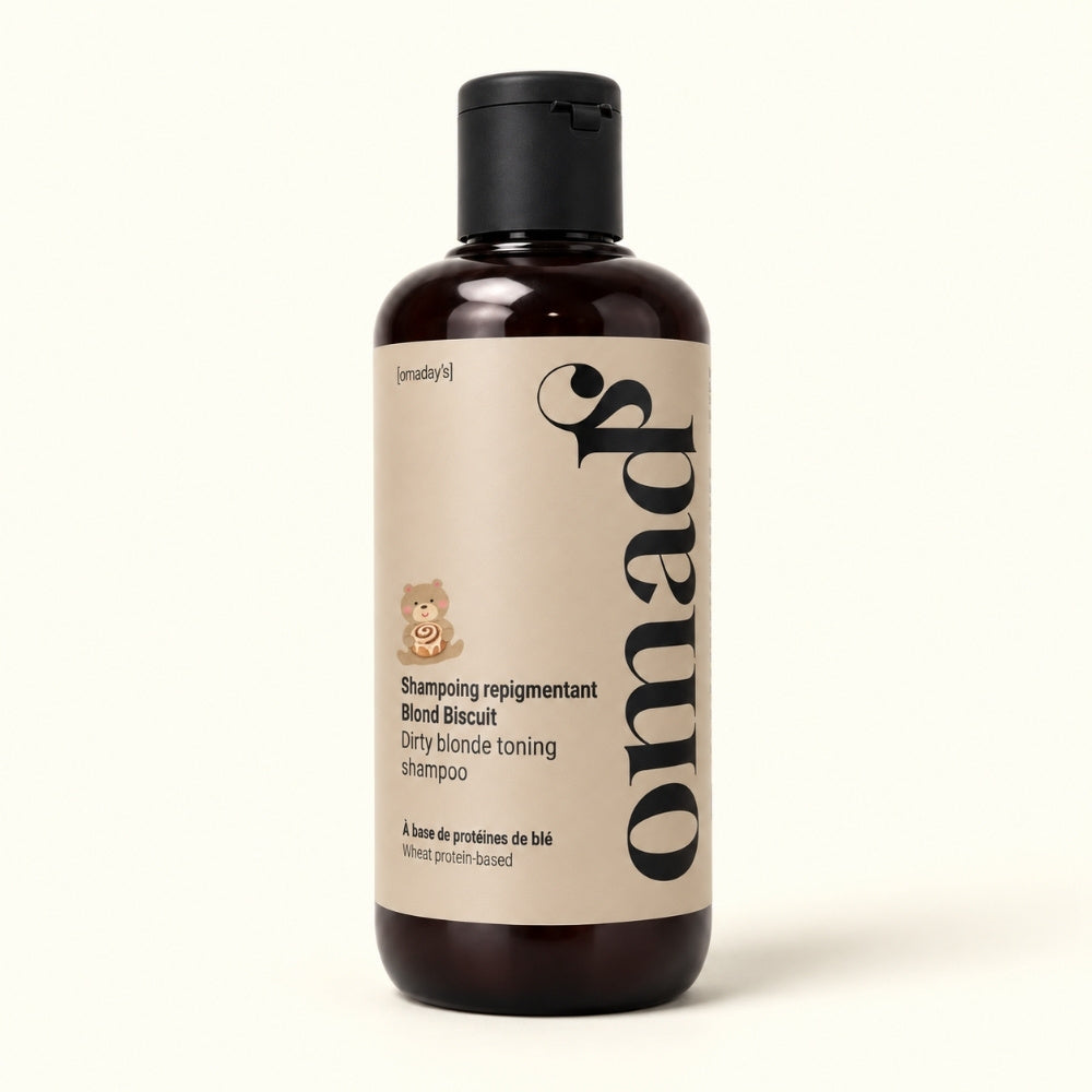 Shampooing repigmentant Blond Biscuit OMAD'S, flacon ambré sur fond crème